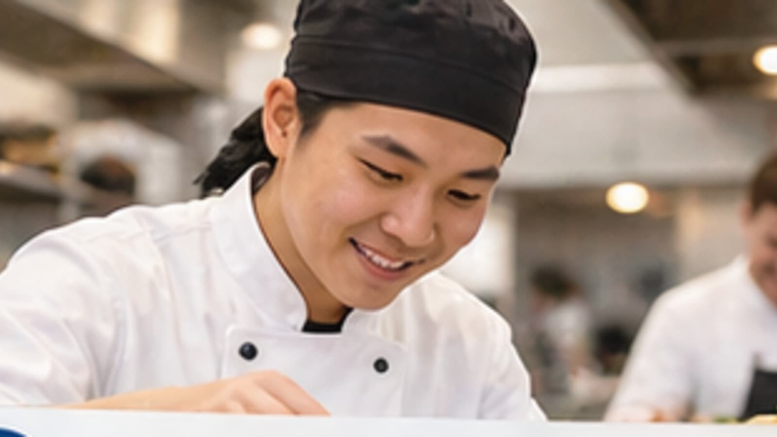 Koch in einer deutschen Restaurantküche bei der Vorbereitung am Pass